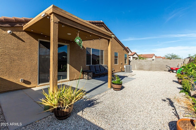 rear view of house featuring a patio, stucco siding, fence, and central AC
