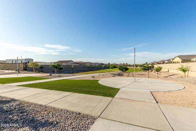 view of sport court with community basketball court, fence, and a residential view