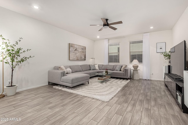 living area with light wood-type flooring, a ceiling fan, recessed lighting, and baseboards