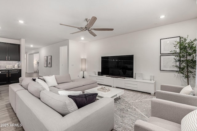 living area with ceiling fan, light wood finished floors, and recessed lighting