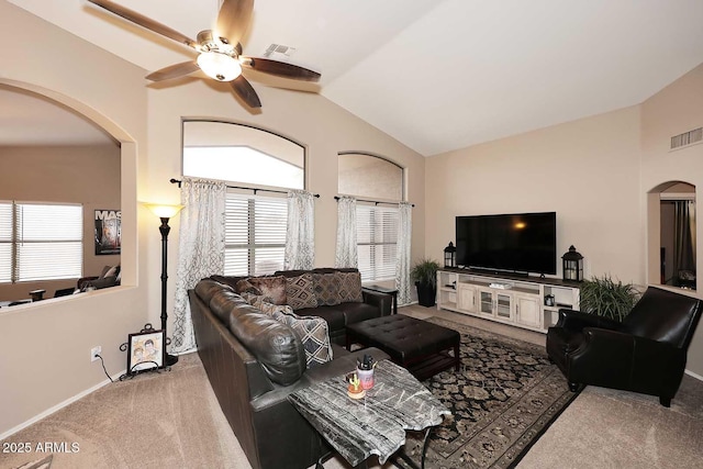 carpeted living area featuring a healthy amount of sunlight, visible vents, lofted ceiling, and arched walkways