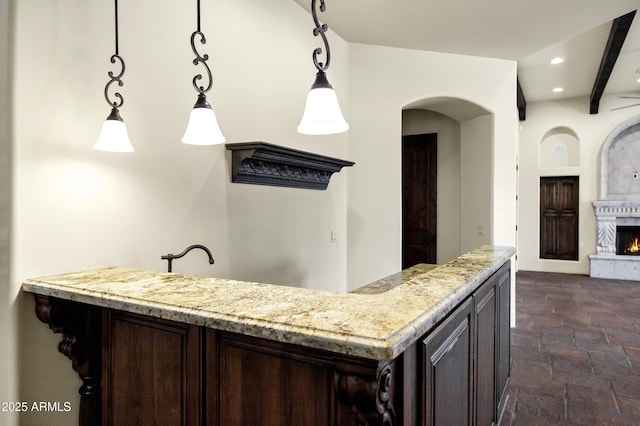 2300 E Sanoque Ct, Gilbert, AZ 85298 - kitchen with stone tile floors, dark brown cabinetry, recessed lighting, light stone countertops, and pendant lighting