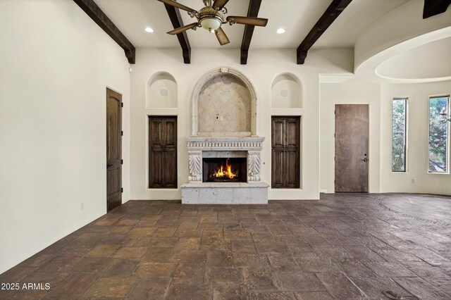 2300 E Sanoque Ct, Gilbert, AZ 85298 - unfurnished living room featuring a premium fireplace, stone tile floors, a ceiling fan, beam ceiling, and recessed lighting