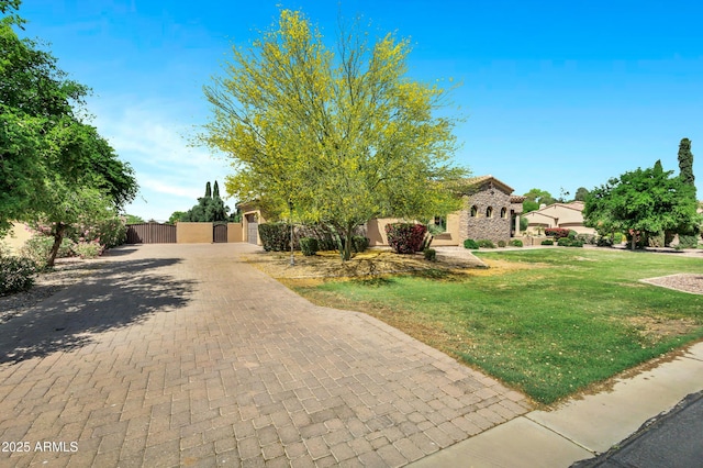 2300 E Sanoque Ct, Gilbert, AZ 85298 - view of property hidden behind natural elements with a gate, decorative driveway, stucco siding, and an attached garage
