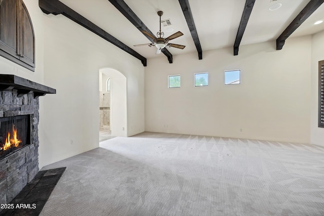 2300 E Sanoque Ct, Gilbert, AZ 85298 - unfurnished living room with arched walkways, light colored carpet, beamed ceiling, a ceiling fan, and a fireplace
