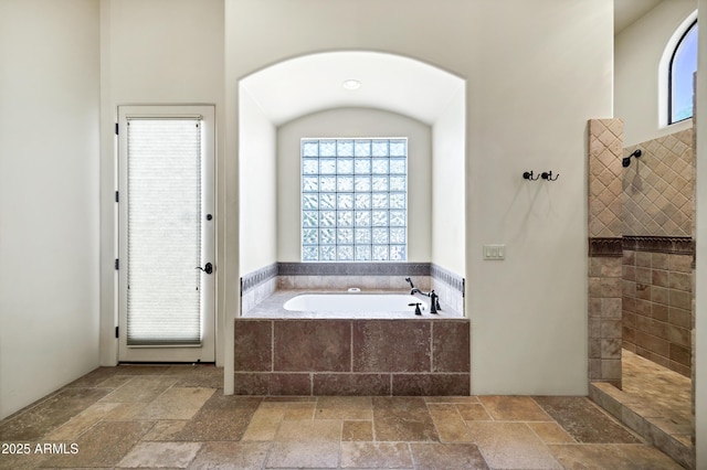 2300 E Sanoque Ct, Gilbert, AZ 85298 - bathroom featuring stone tile floors, a bath, and a walk in shower