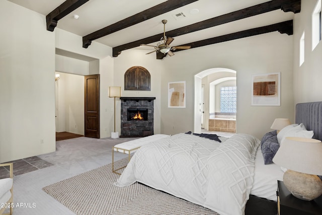 2300 E Sanoque Ct, Gilbert, AZ 85298 - bedroom featuring carpet flooring, a lit fireplace, arched walkways, beam ceiling, and connected bathroom