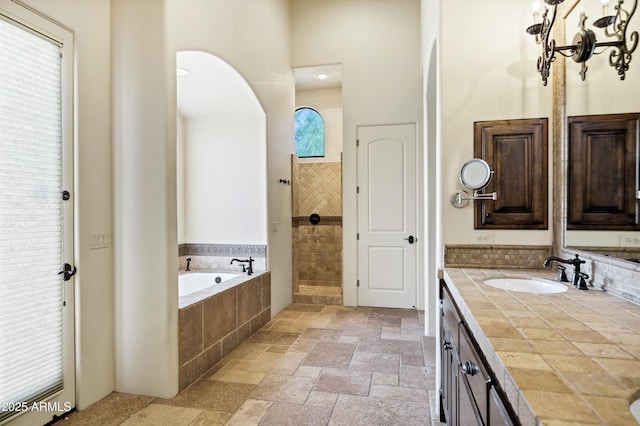 2300 E Sanoque Ct, Gilbert, AZ 85298 - bathroom with stone tile flooring, vanity, a bath, a towering ceiling, and a tile shower