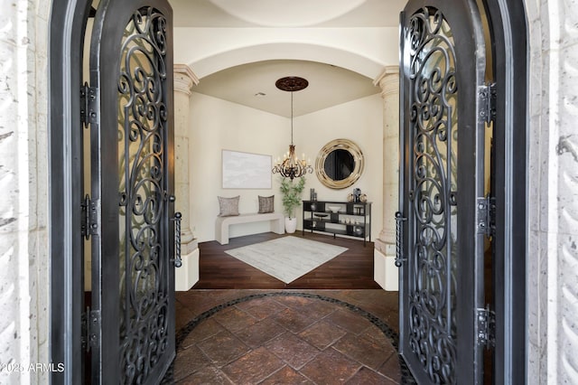 2300 E Sanoque Ct, Gilbert, AZ 85298 - foyer featuring arched walkways, a chandelier, ornate columns, and stone tile floors