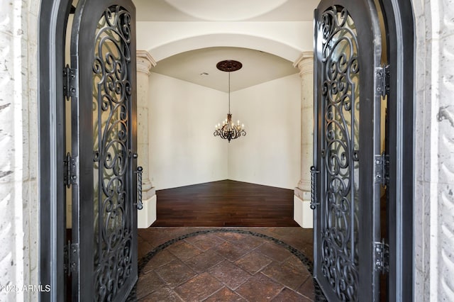2300 E Sanoque Ct, Gilbert, AZ 85298 - entryway with arched walkways, a chandelier, stone tile floors, and ornate columns
