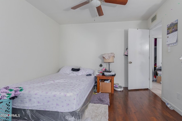 bedroom featuring a ceiling fan, baseboards, visible vents, and wood finished floors