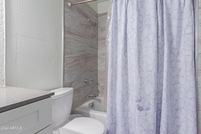 bathroom featuring shower / bath combination with curtain, a textured wall, vanity, and toilet