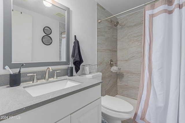 bathroom featuring visible vents, a tile shower, vanity, and toilet