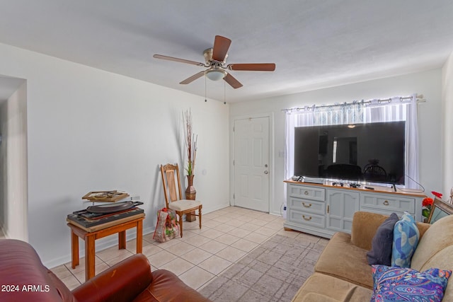 living room with ceiling fan, baseboards, and light tile patterned floors