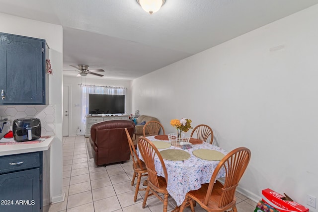 dining area with light tile patterned floors, ceiling fan, and baseboards