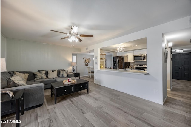 living room with light hardwood / wood-style floors and ceiling fan