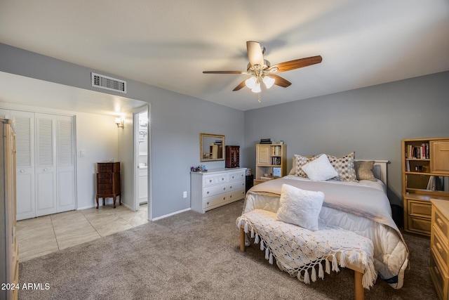 bedroom with ceiling fan, light carpet, and a closet