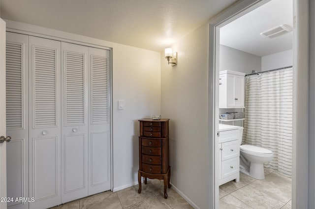 bathroom featuring walk in shower, tile patterned flooring, vanity, and toilet