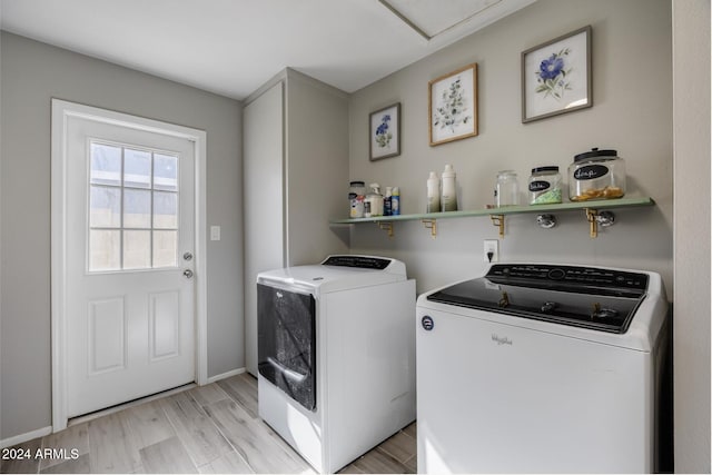 clothes washing area featuring light hardwood / wood-style floors and washing machine and clothes dryer