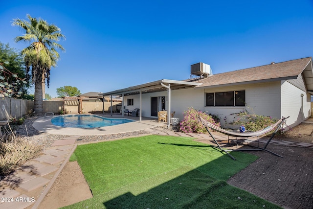 back of property with a lawn, a fenced in pool, and a patio