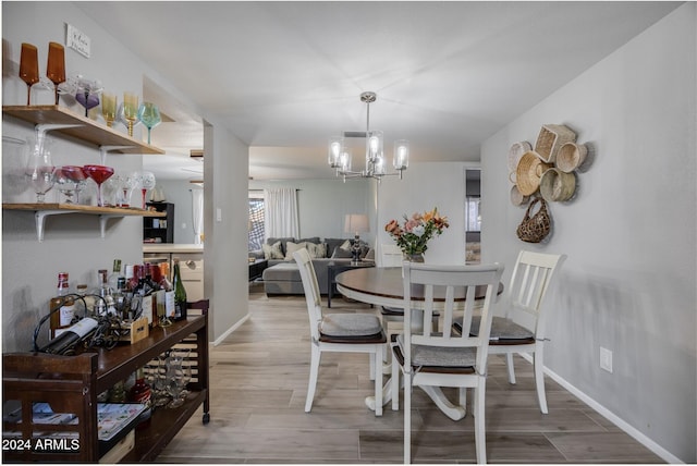 dining space with hardwood / wood-style flooring and a notable chandelier