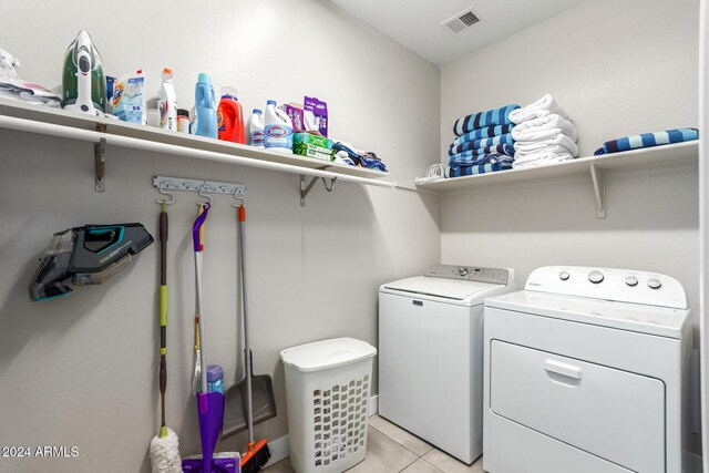 laundry area featuring washing machine and dryer and light tile patterned flooring