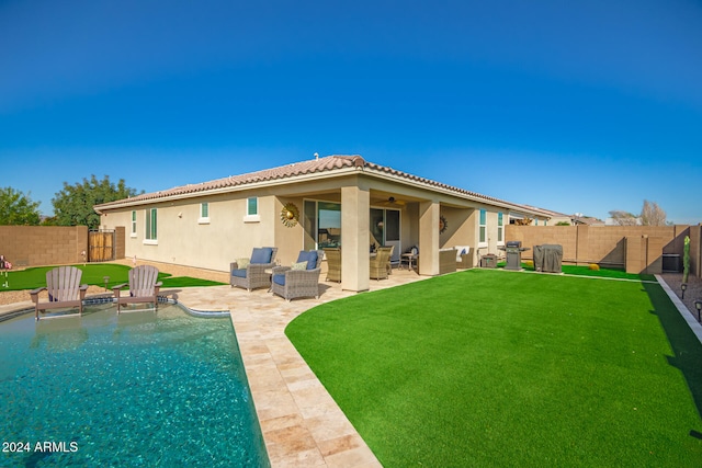 rear view of house featuring a fenced in pool, an outdoor hangout area, a patio area, and a yard