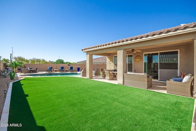 view of yard with an outdoor living space, ceiling fan, a fenced in pool, and a patio area