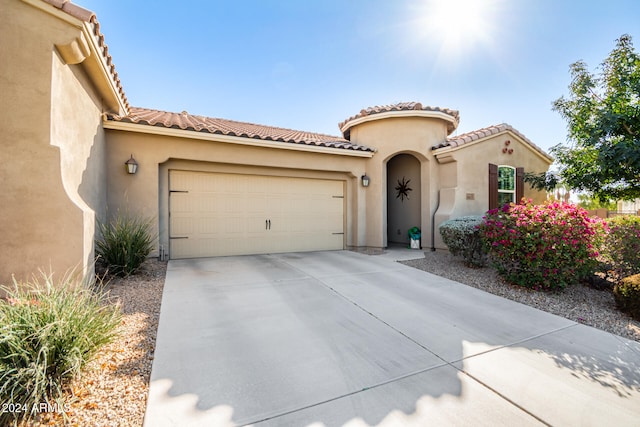 mediterranean / spanish-style home with a garage