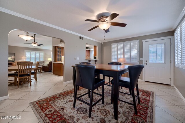 dining area featuring ceiling fan, light tile patterned floors, and crown molding