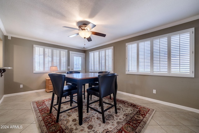 dining space with ceiling fan, crown molding, light tile patterned flooring, and a wealth of natural light