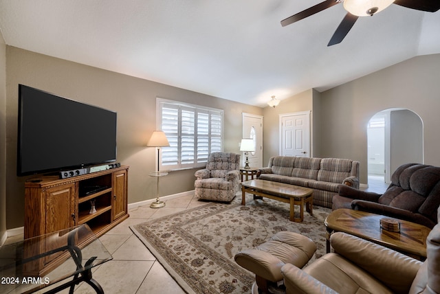 living room with ceiling fan, vaulted ceiling, and light tile patterned floors