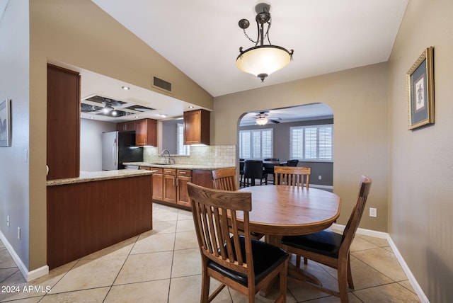 tiled dining area with sink, ceiling fan, and vaulted ceiling