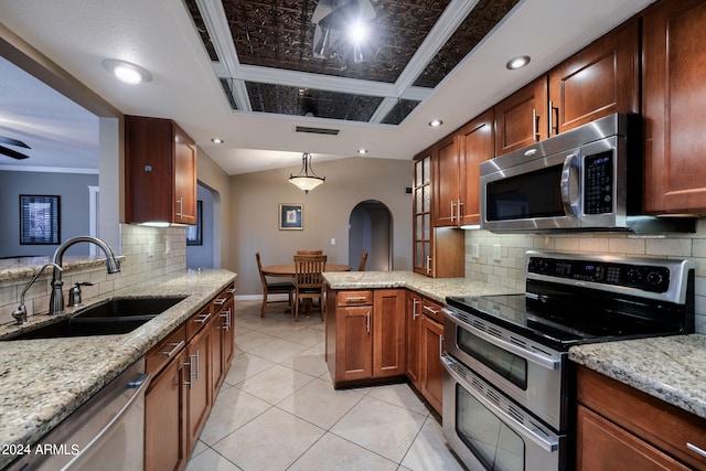 kitchen featuring sink, kitchen peninsula, appliances with stainless steel finishes, and light stone countertops