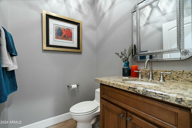 bathroom with vanity, toilet, and baseboards