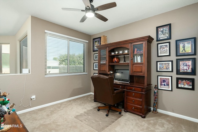 home office featuring a ceiling fan, light colored carpet, and baseboards