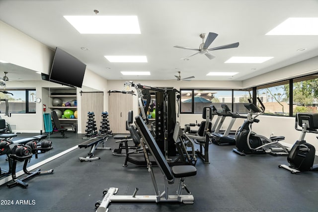 exercise room with ceiling fan, a wealth of natural light, and baseboards