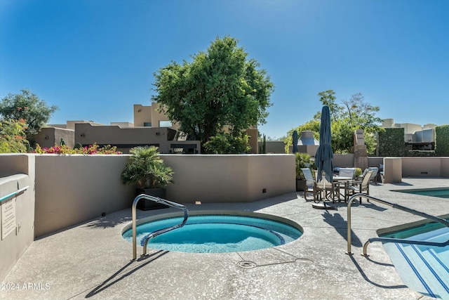 view of swimming pool with a patio area and a hot tub