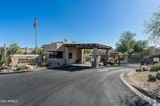 view of road featuring a gate, a gated entry, and curbs