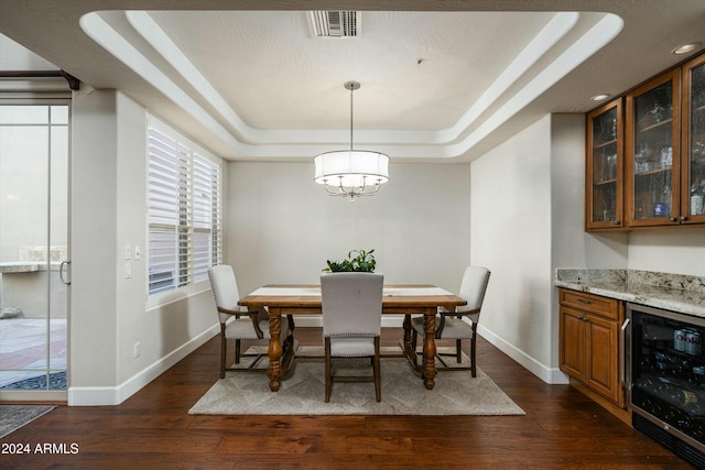 dining area featuring beverage cooler, baseboards, a raised ceiling, dark wood-style floors, and a chandelier