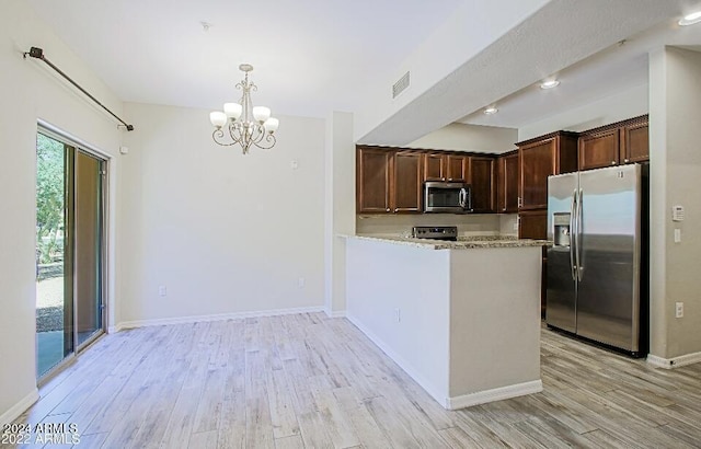 3935 E Rough Rider Rd Unit 1101, Phoenix, AZ 85050 - kitchen with stainless steel appliances, light wood-type flooring, a chandelier, and light stone counters