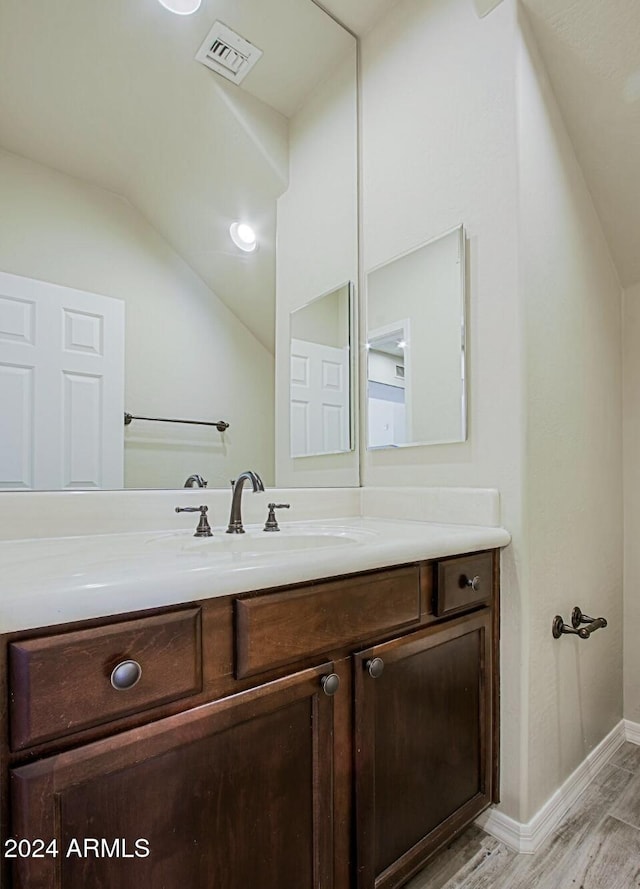 3935 E Rough Rider Rd Unit 1101, Phoenix, AZ 85050 - bathroom featuring vanity, wood finished floors, and vaulted ceiling