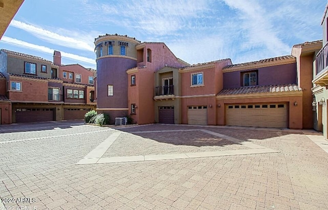 3935 E Rough Rider Rd Unit 1101, Phoenix, AZ 85050 - view of front of house featuring stucco siding, driveway, a garage, and a tile roof