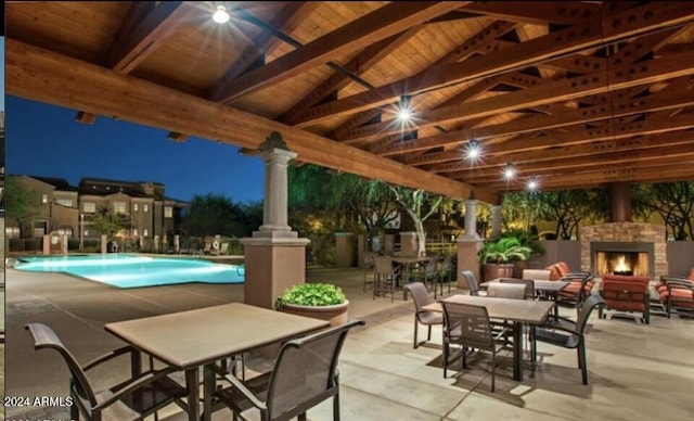3935 E Rough Rider Rd Unit 1101, Phoenix, AZ 85050 - view of patio with an outdoor stone fireplace, outdoor dining space, and an outdoor pool