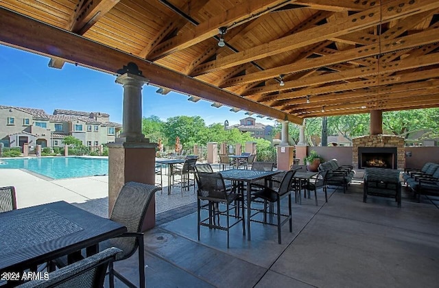 3935 E Rough Rider Rd Unit 1101, Phoenix, AZ 85050 - view of patio with an outdoor stone fireplace, outdoor dining area, and a community pool