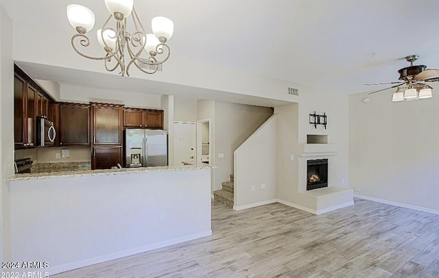 3935 E Rough Rider Rd Unit 1101, Phoenix, AZ 85050 - kitchen with appliances with stainless steel finishes, light wood-style flooring, light stone counters, and a chandelier