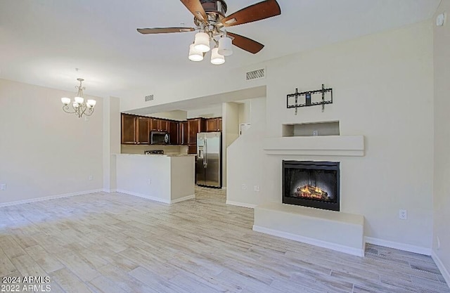 3935 E Rough Rider Rd Unit 1101, Phoenix, AZ 85050 - unfurnished living room featuring a chandelier, a warm lit fireplace, a ceiling fan, and light wood-type flooring