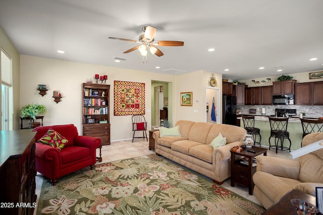 living area with light tile patterned floors, a ceiling fan, and recessed lighting