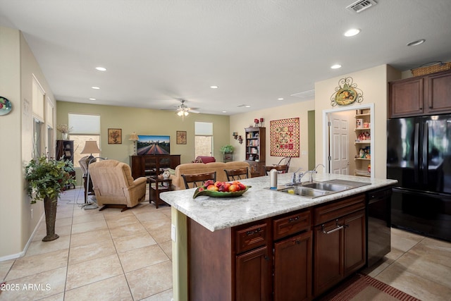 kitchen with a sink, light tile patterned floors, black appliances, and visible vents