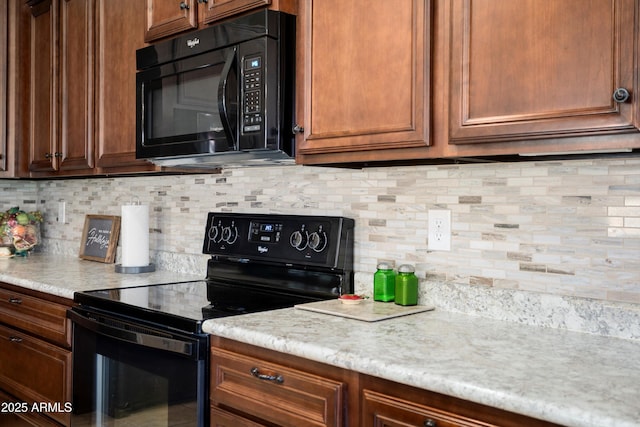 kitchen with light countertops, backsplash, and black appliances